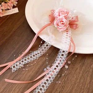 Close-up detail of pink floral hair clip with delicate lace and satin ribbons