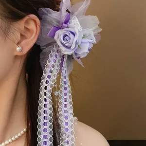 Detailed view of sweet purple lace flower hair clip with elegant ribbon on model