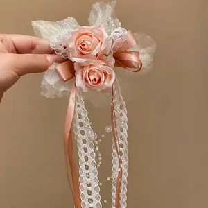 Detailed view of a sweet pink rose hair clip with lace ribbons and pearl strands