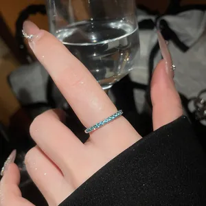 Close-up of a mint green zircon eternity ring on a finger with a clear aesthetic