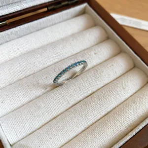 Close-up of a silver band ring featuring a row of sparkling mint green zircons