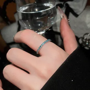 Close-up detail of a minimalist mint green zircon eternity band ring worn on hand