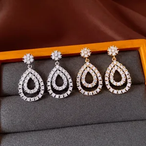 Elegant close-up view of zircon teardrop drop earrings in gold and silver finishes