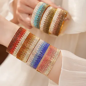 Primo piano di bracciali elastici in strass colorati multistrato con cristalli sfumati.