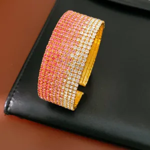 Primo piano di un elegante bracciale rigido dorato con strass rosa sfumati a più strati