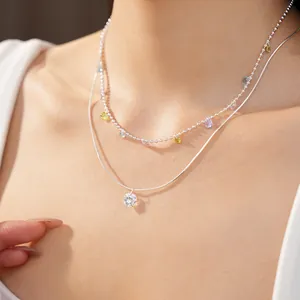 Dettaglio di una collana d'argento a due strati con ciondoli in zircone colorati