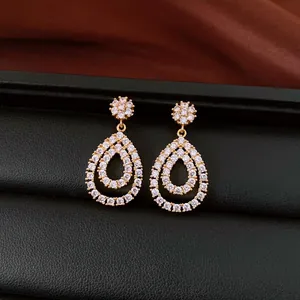 Detailed view of 18K gold plated teardrop dangle earrings with sparkling white cubic zirconia.