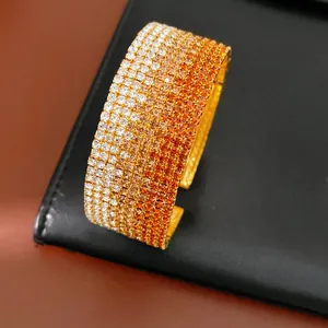 Dettaglio macro di un bracciale rigido elastico con strass sfumati multistrato arancio