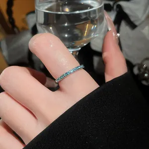 Detailed macro view of a silver eternity ring featuring mint green zircon stones.