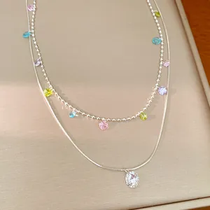 Primo piano di un'elegante collana a due strati con frange di zirconi colorati e catena argento