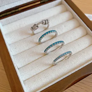 Elegant mint green zircon stackable rings and a rotating bead fidget ring in a box.