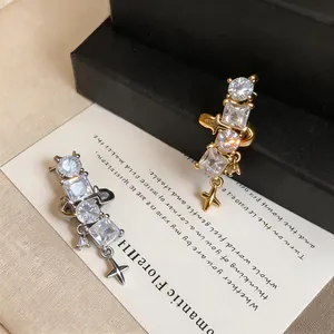 Close-up detail view of gold and silver zircon star ear cuffs on elegant artistic card