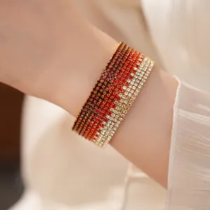 Vista dettagliata di un bracciale elastico multistrato con strass sfumati in rosso e bianco.
