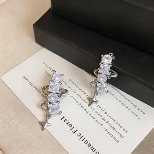 Detailed view of silver star ear clips featuring sparkling clear cubic zirconia stones.
