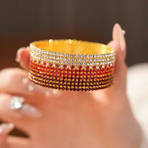 Primo piano di un elegante bracciale rigido multistrato con strass rossi sfumati.