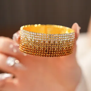 Primo piano di bracciale elastico multistrato con strass sfumati argento e ambra