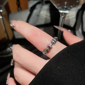 Macro view of a sparkling zircon-encrusted silver ring on a finger for jewelry detail.