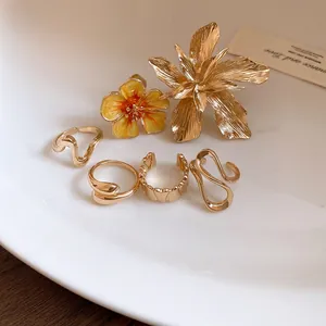 Vista macro dettagliata di eleganti anelli dorati con fiori 3D su sfondo minimalista