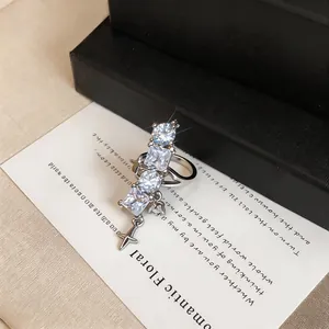 Close-up detail of elegant silver ear cuff with sparkling zircons and a star charm