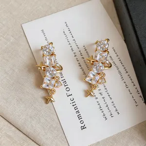 Detailed view of gold star ear clips featuring sparkling round and square zircons