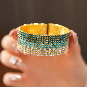 Dettaglio di un bracciale a polsino multistrato con strass blu sfumati scintillanti