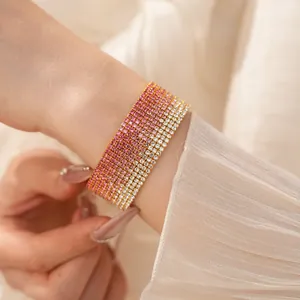 Primo piano di bracciale elastico multi-fila con strass sfumati rosa e bianchi al polso