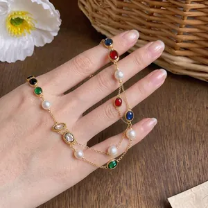 Elegant layered gold necklace featuring oval colorful zircons and freshwater pearls