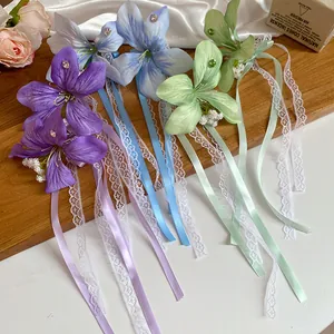 Détail de pinces à cheveux fleur en tissu avec rubans de dentelle et strass