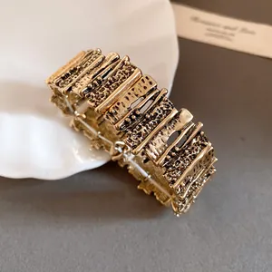 Close-up detail view of a vintage gold-tone irregular segmented metal cuff bracelet