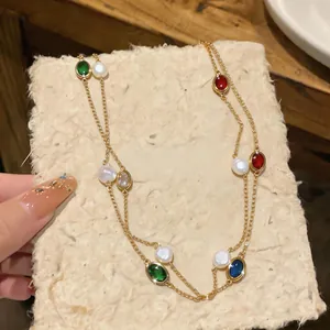 Macro view of gold double layer necklace with oval zircons and freshwater pearls