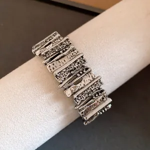 Detailed view of a vintage silver-tone metal bracelet with irregular textured geometric links.