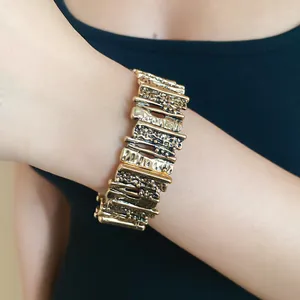 Close-up of vintage textured gold metal bracelet with irregular geometric links.
