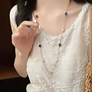 Detailed view of a stylish necklace featuring oval zircons and freshwater pearls on a model