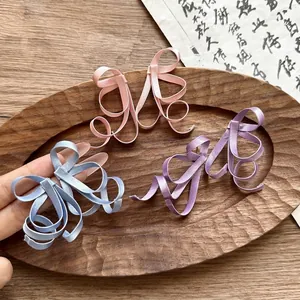 Detail of anti-gravity bow earrings in pink, blue, and purple for a vintage Chinese look.