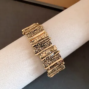 Close-up of vintage gold geometric patchwork bracelet with irregular metal texture