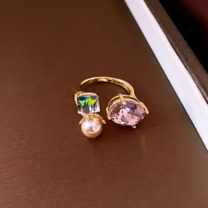 Elegant gold plated open ring featuring an oval purple crystal and a lustrous pearl accent