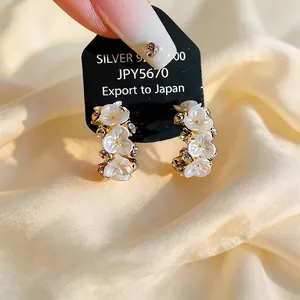 Elegant French style floral zircon earrings with white petals on warm satin fabric
