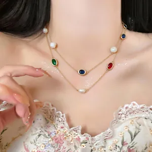 Detail of elegant double-layered gold necklace with oval zircons and freshwater pearls