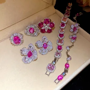 Elegantes Schmuckset mit rosa Zirkonia-Blumen, bestehend aus Ringen, Ohrringen und Armband.