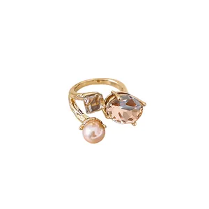 Elegant gold-plated open ring featuring a large oval champagne crystal and a pink pearl