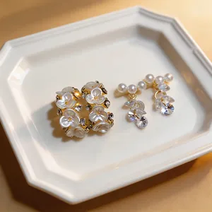 Close-up of elegant French style earrings with white pearls and sparkling zircons
