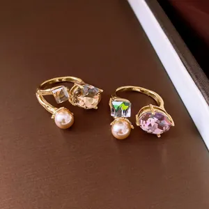 Elegant open rings featuring faceted purple crystals and champagne pearls in detail.