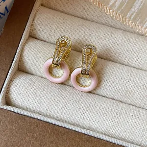 Detailansicht von 14k vergoldeten Creolen mit Zirkonia und rosa Emaille-Kreisen.