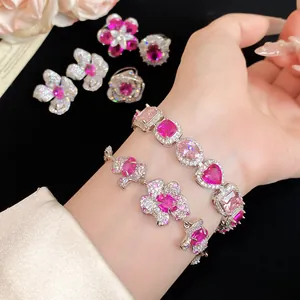 Detailaufnahme eines funkelnden rosa Zirkon-Blumenarmbands und Herzschmuck-Sets.