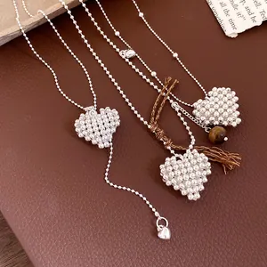Detailed close-up of woven silver bead heart pendants with adjustable drawstring ball chains.