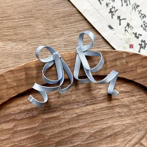 Close-up view of elegant blue ribbon anti-gravity bow earrings with a New Chinese style