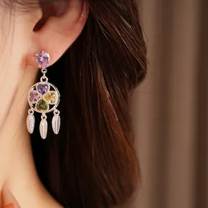 Detail of retro zircon earrings with colorful flower pattern and silver feather tassels