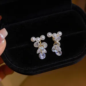 Close-up of elegant French style pearl earrings with sparkling cluster zircon tassels