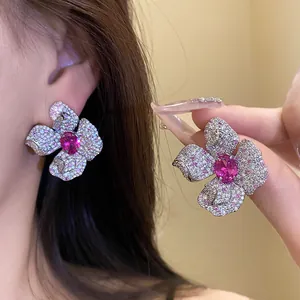 Detailansicht der silbernen Ohrstecker in Blumenform mit pinkfarbenem Zirkonia-Stein