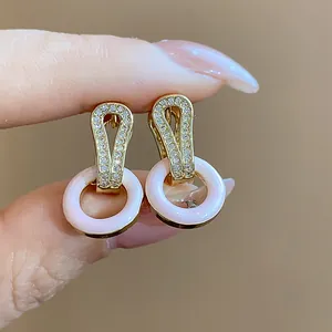 Detailansicht der vergoldeten Ohrringe mit rosa Emaille-Ringen und Zirkonsteinen